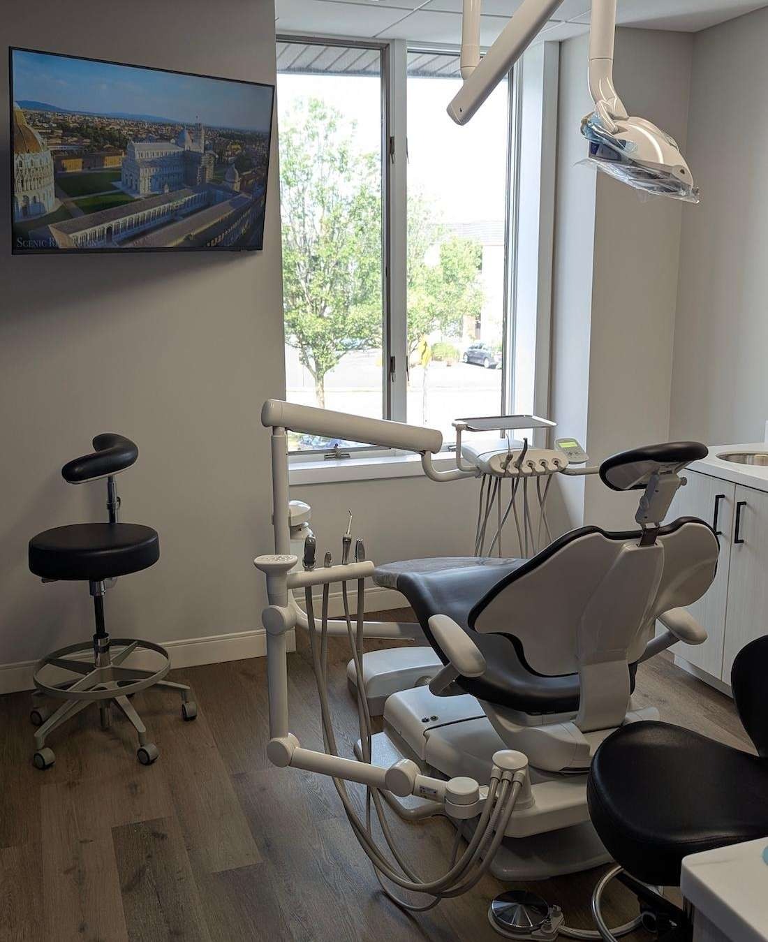 Treatment room with a dental chair and a window at Tooth Doc